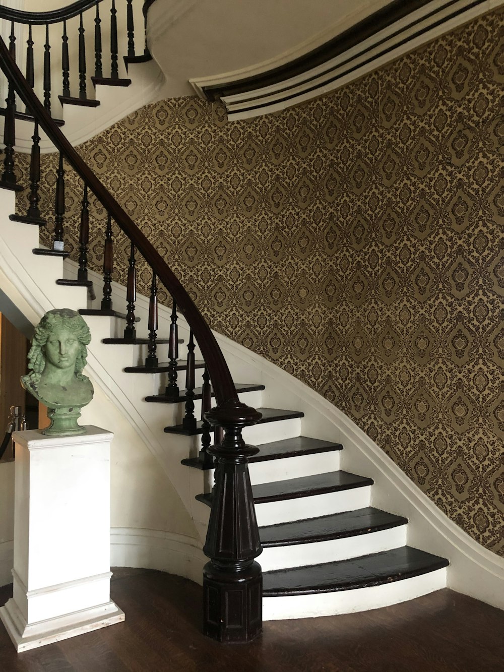 green ceramic statue on brown and white staircase