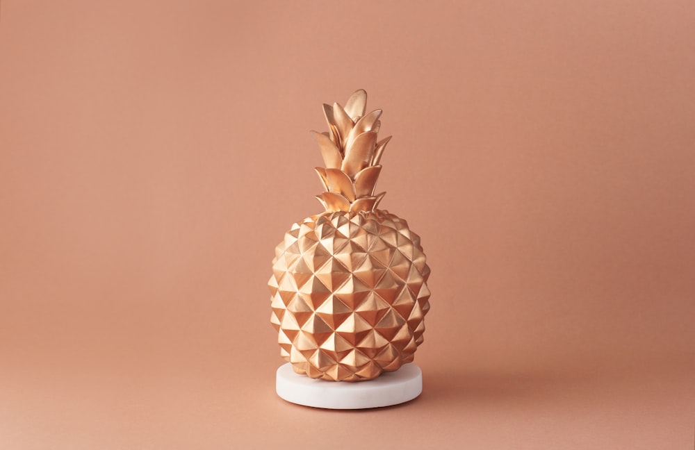 Fruit d’ananas sur vase en céramique blanc et brun