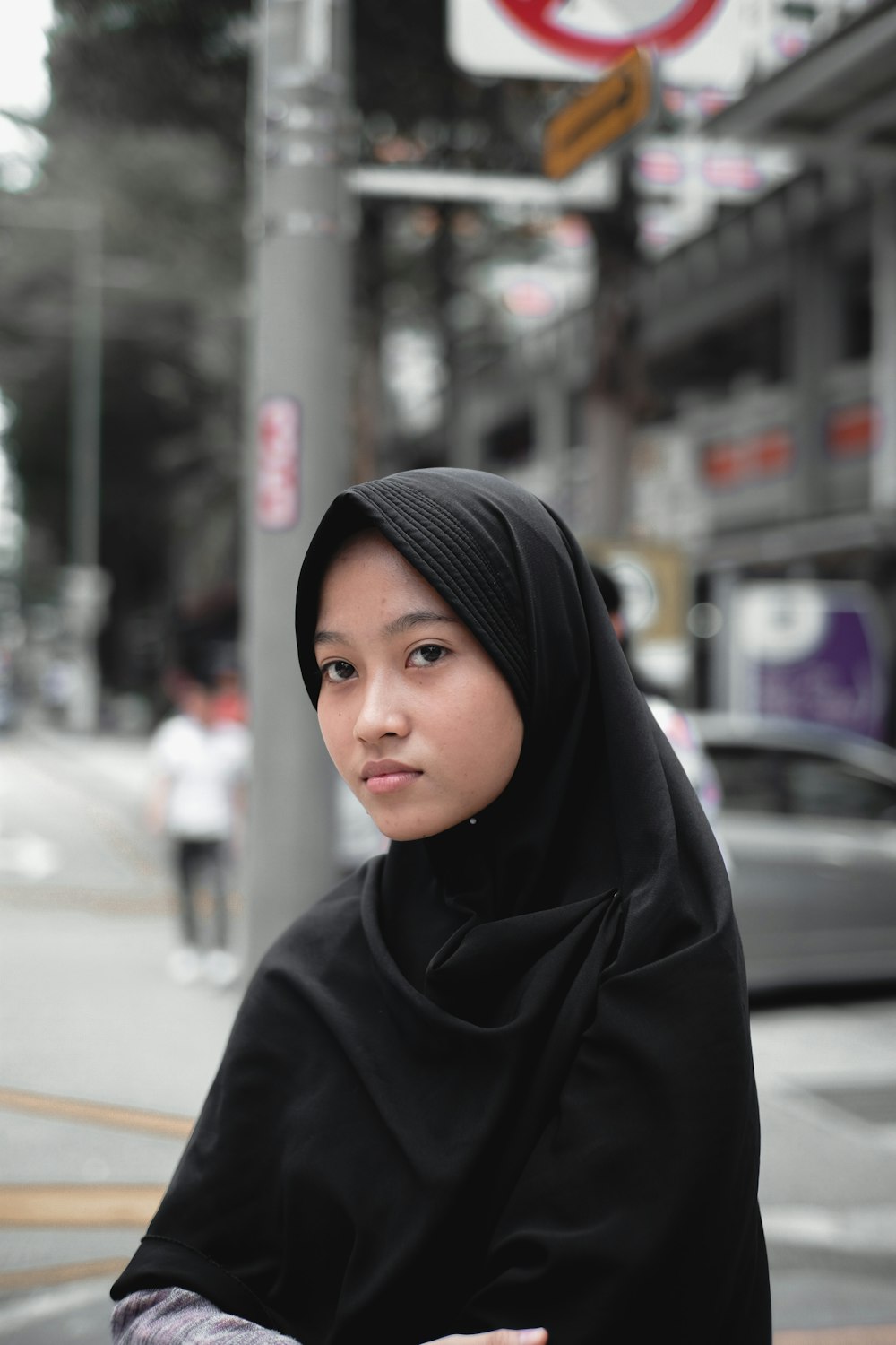 woman in black hijab standing on street during daytime