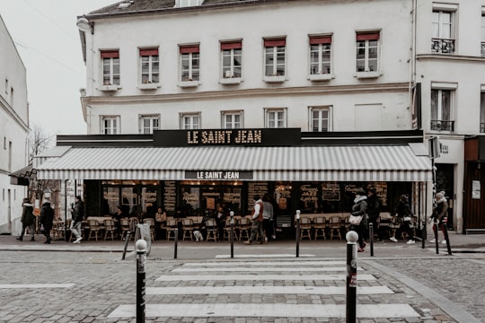 people walking on sidewalk near white concrete building during daytime in Le Saint Jean France