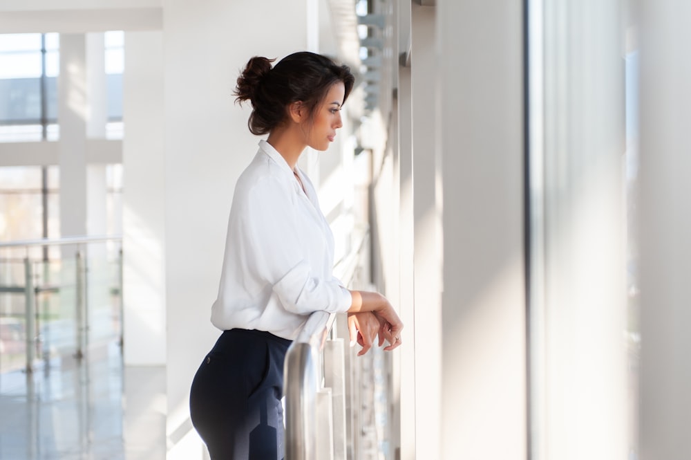 woman in white long sleeve shirt and blue pants sitting on white chair