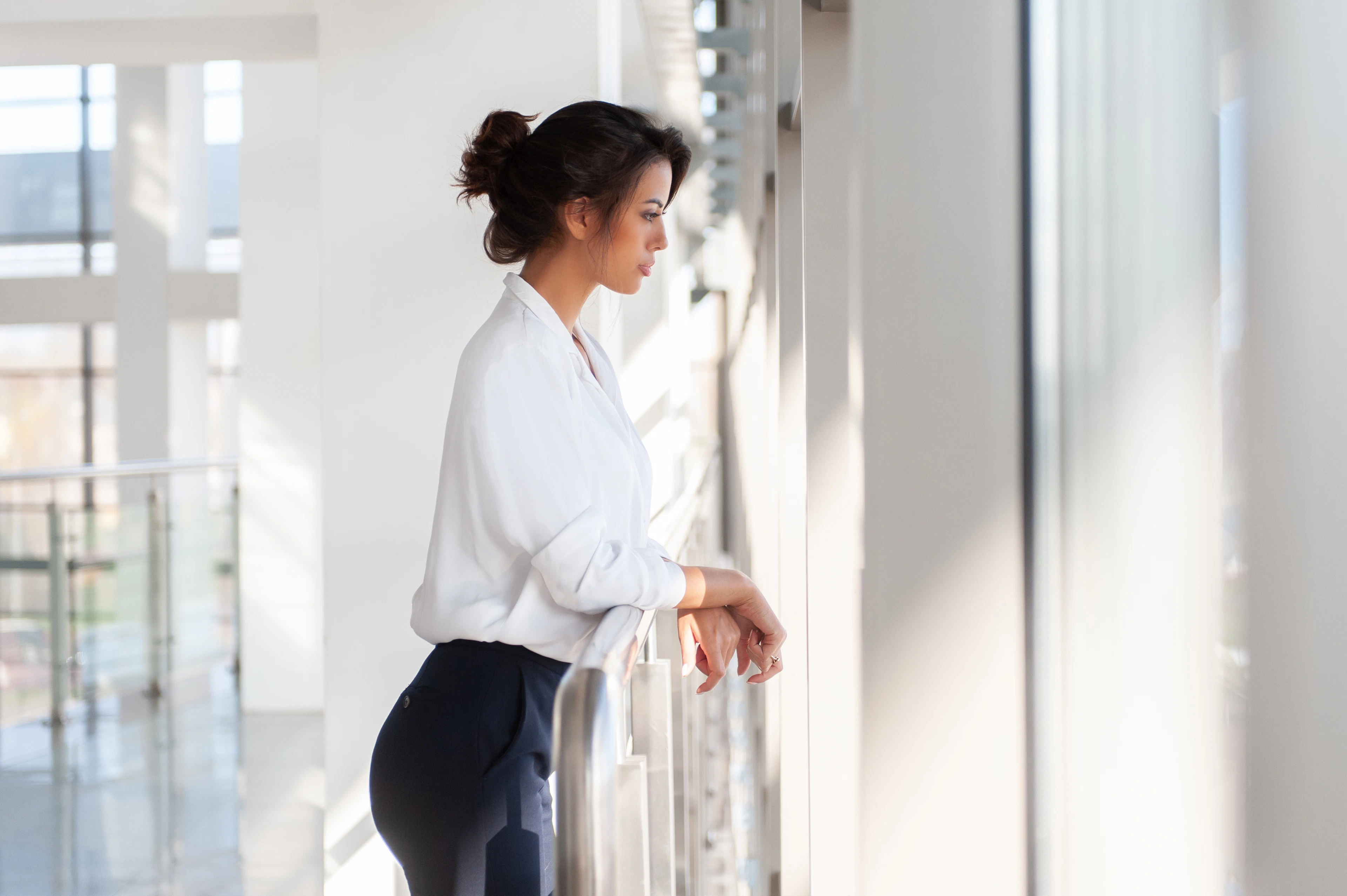 Elena Marlow, Creative Director, standing by a tall studio window in soft morning light
