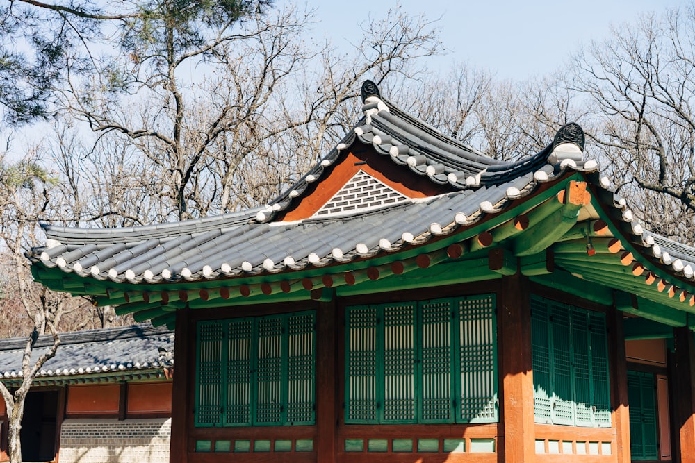 green and brown wooden house near bare trees during daytime