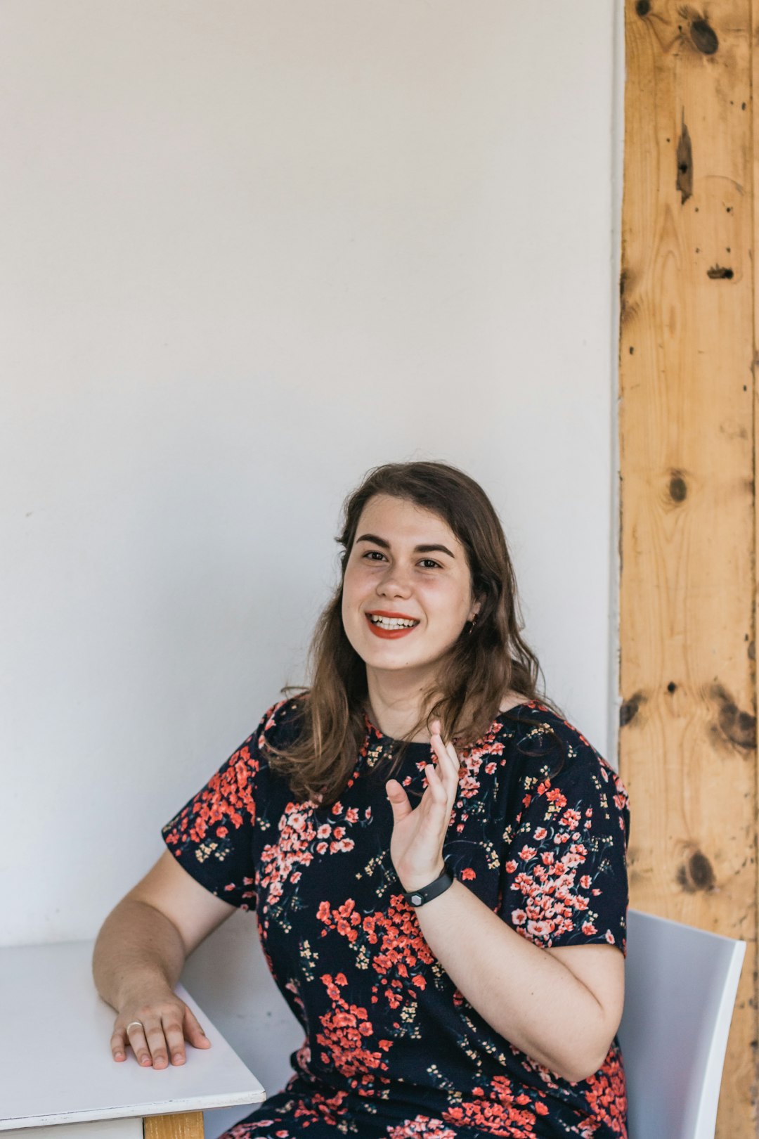 woman in black white and red floral dress smiling