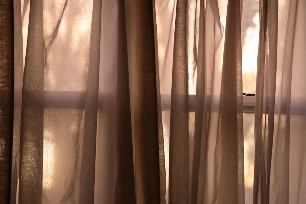 white curtain near white textile