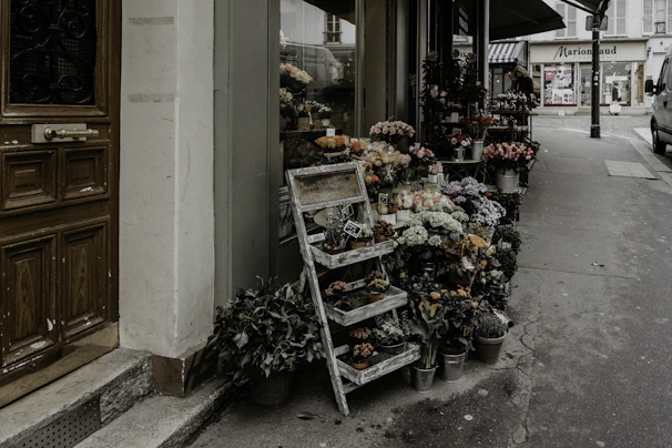 Vintage style image of a small kiosk selling flowers near an old cemetery.