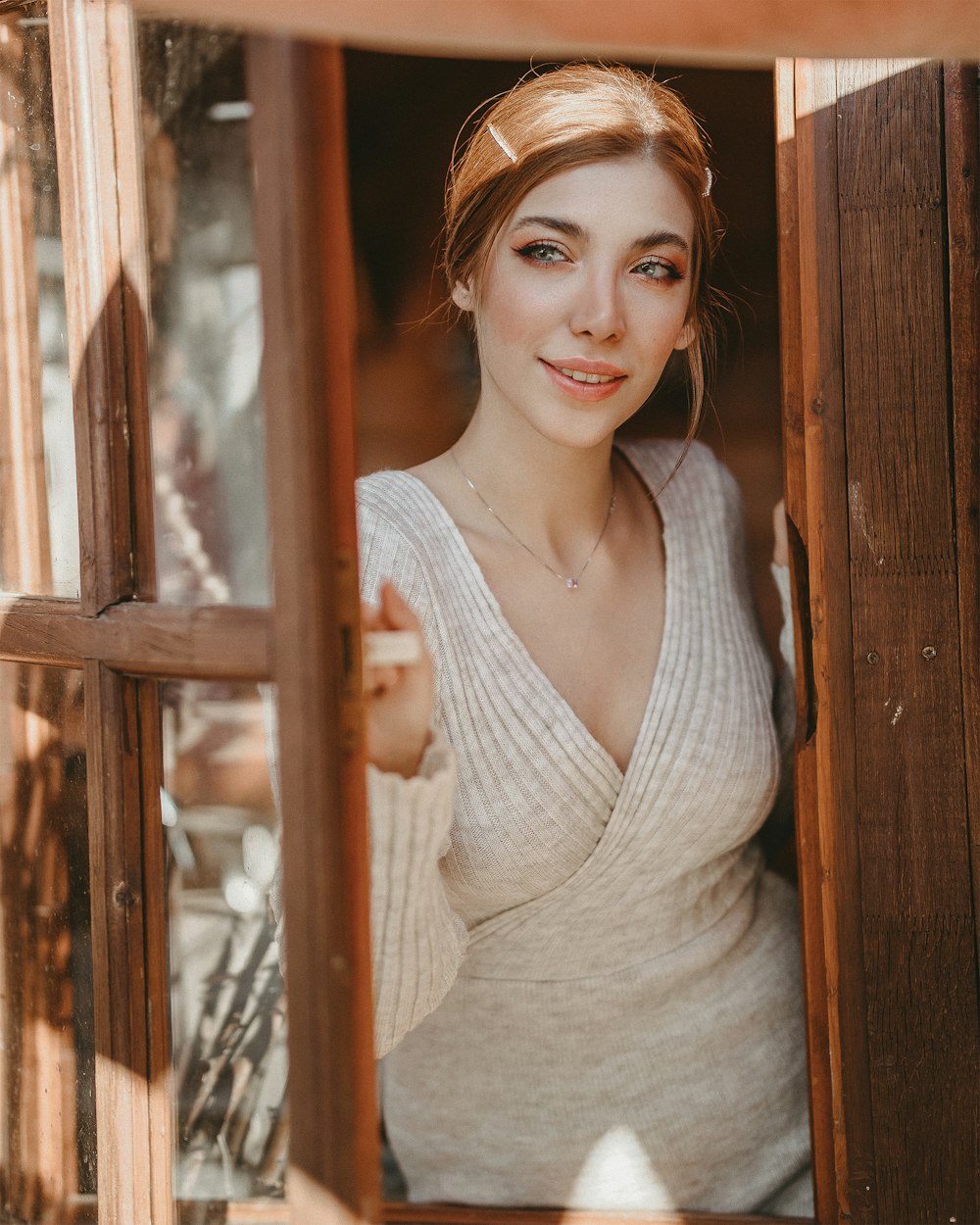 woman in white tank top standing beside brown wooden fence