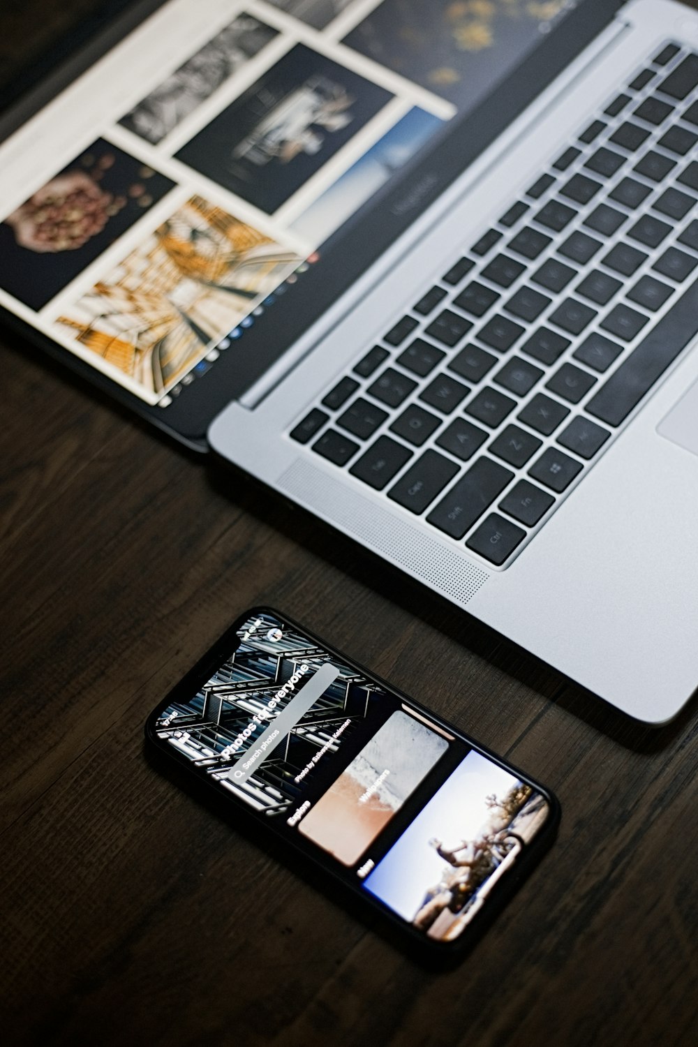 black and white smartphone beside macbook pro