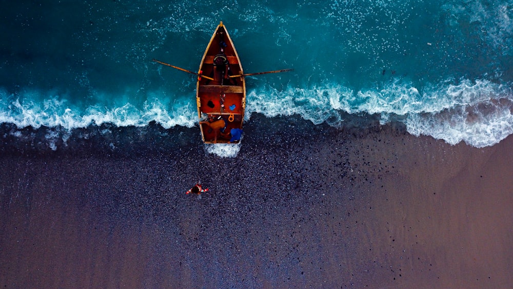 red and yellow kayak on beach shore during daytime