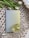 A textured, woven surface with a pastel-colored book titled 'Explore Your Inner World for Happiness & Growth' is accompanied by a glass cup filled with light-colored tea. A few white tulips with green leaves provide an elegant touch.