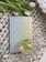 A textured, woven surface with a pastel-colored book titled 'Explore Your Inner World for Happiness & Growth' is accompanied by a glass cup filled with light-colored tea. A few white tulips with green leaves provide an elegant touch.