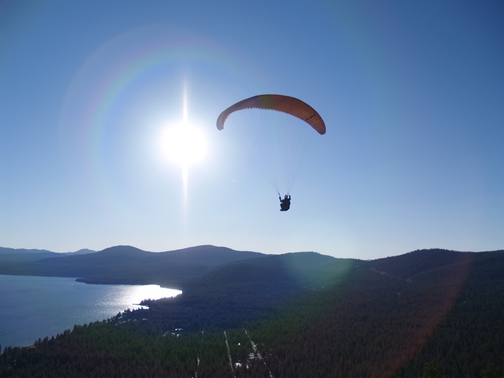 person in parachute over the sea during daytime