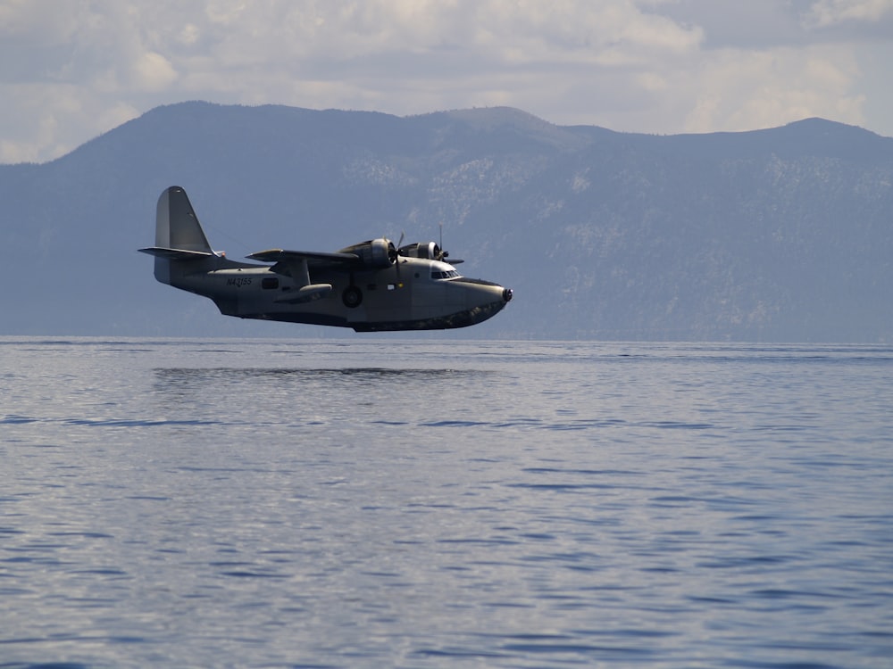 black fighter jet flying over the sea during daytime