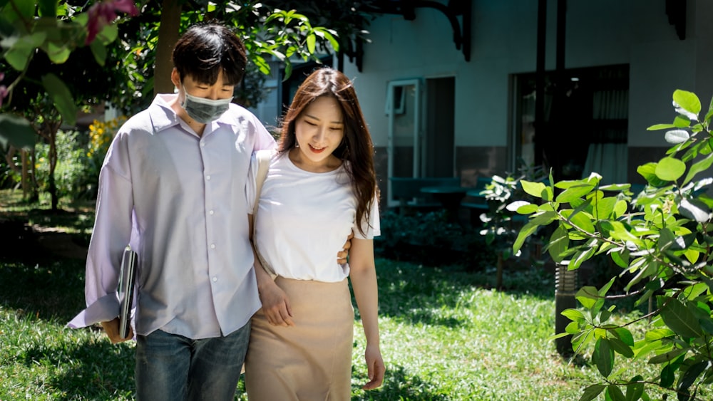 man in white button up shirt standing beside woman in white sleeveless shirt