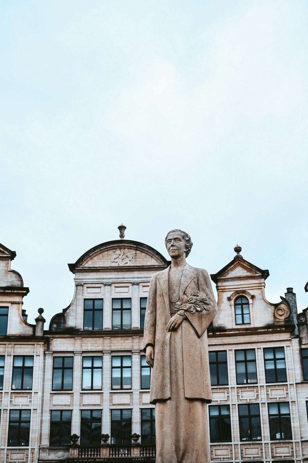 brown concrete statue near white concrete building during daytime