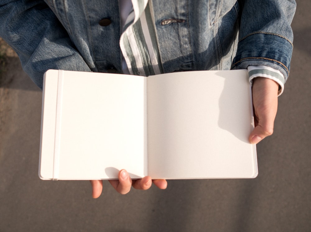 personne tenant une boîte rectangulaire blanche