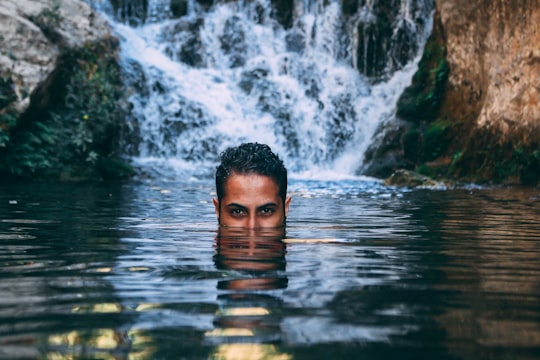 man in water near rocky mountain during daytime in Chefchaouen Morocco