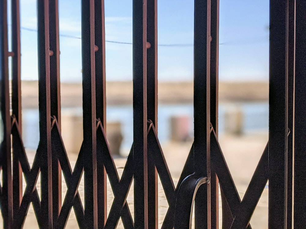 black metal fence near body of water during daytime