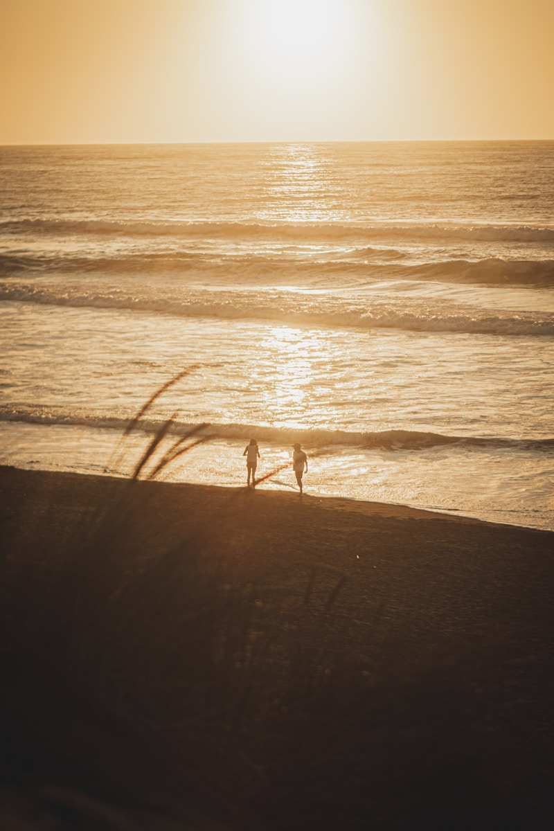 Pareja caminando por la playa de Pichilemu al atardecer