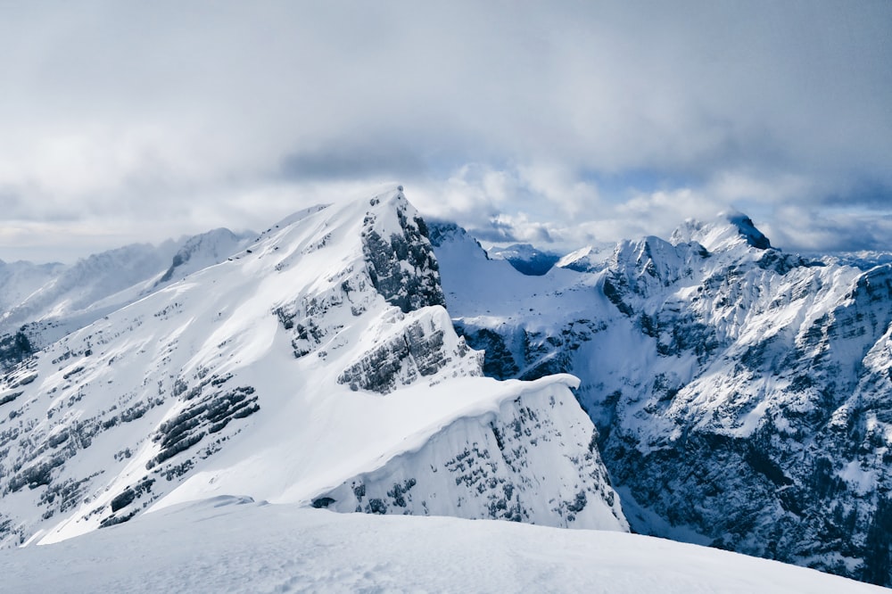 snow covered mountain under cloudy sky during daytime