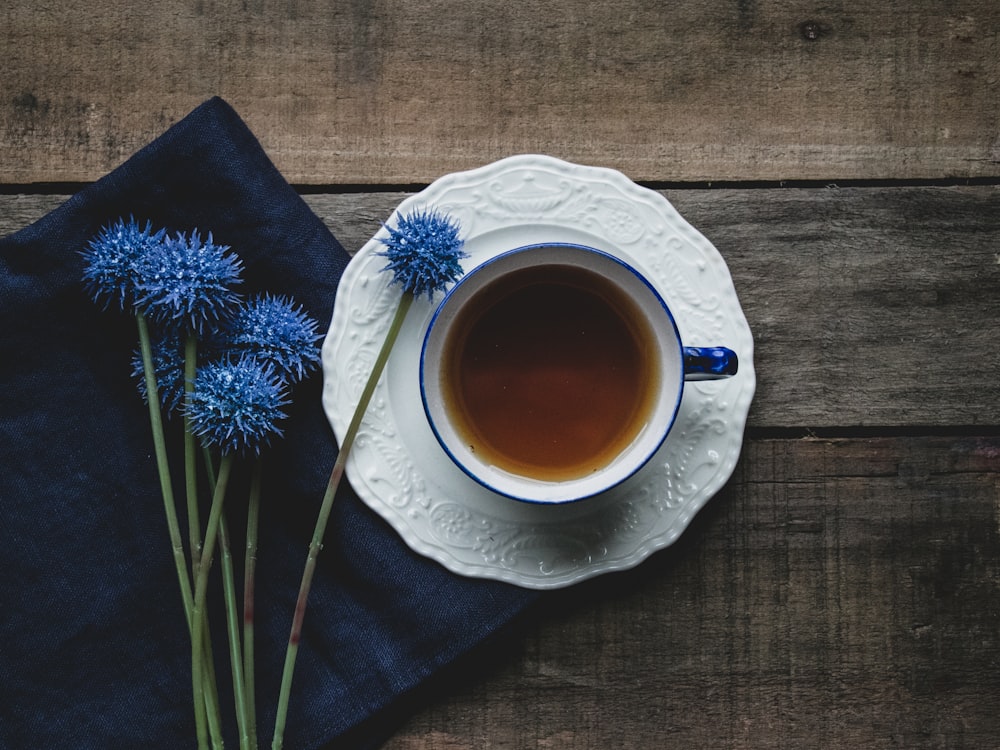 white ceramic cup on white and blue floral ceramic saucer