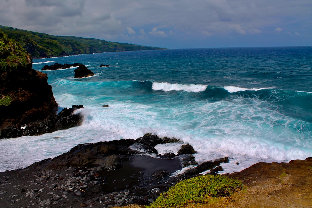 ocean waves crashing on rocks during daytime