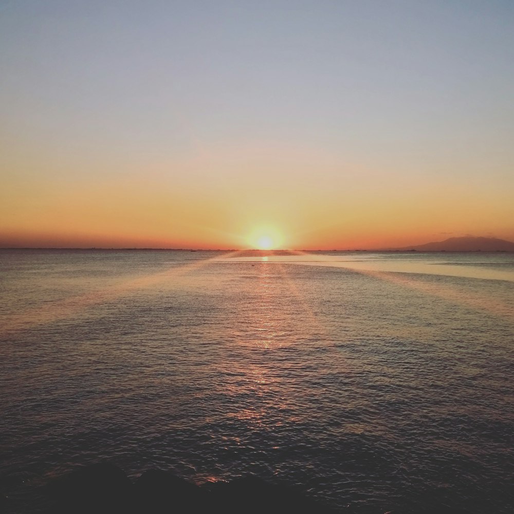 body of water during sunset