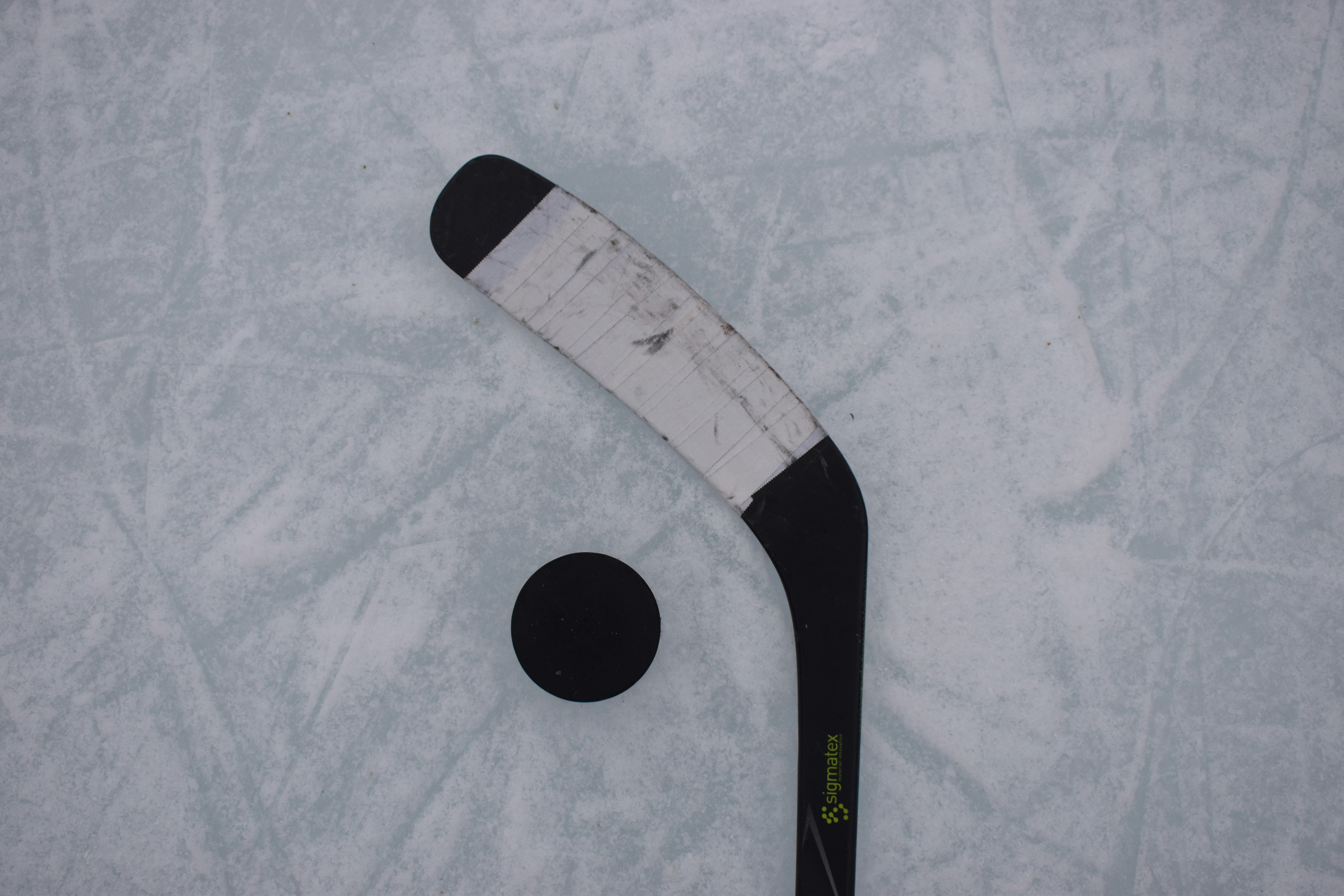 hockey sticks and puck on a rink