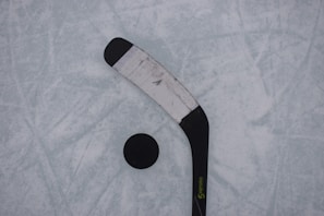 A close-up of a field hockey stick and ball on the field.