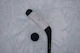 Close-up of a hockey puck sliding across the ice with players in the background.