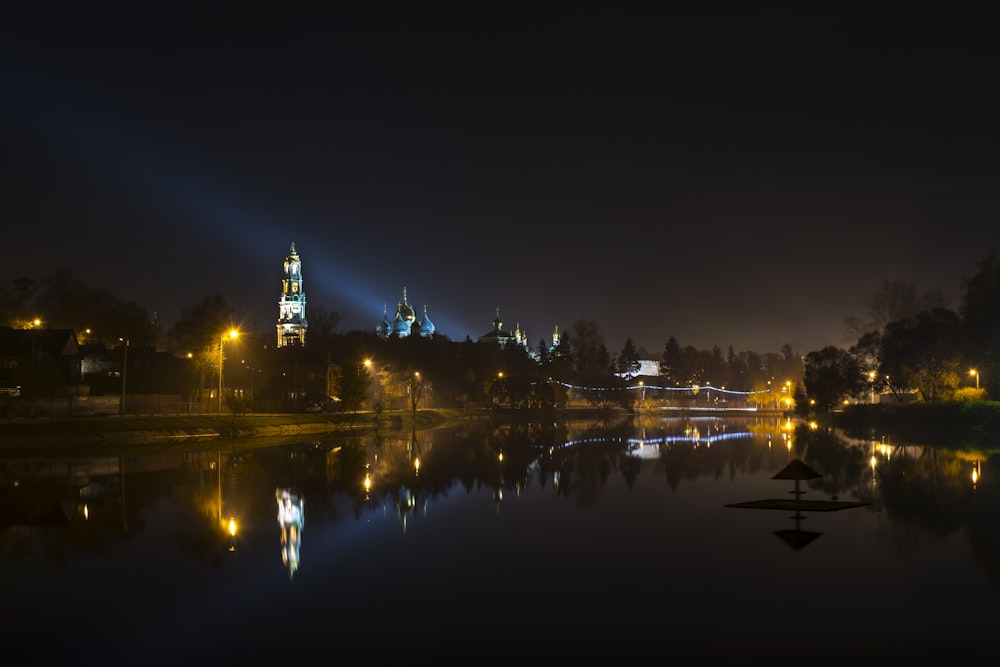 body of water near city buildings during night time