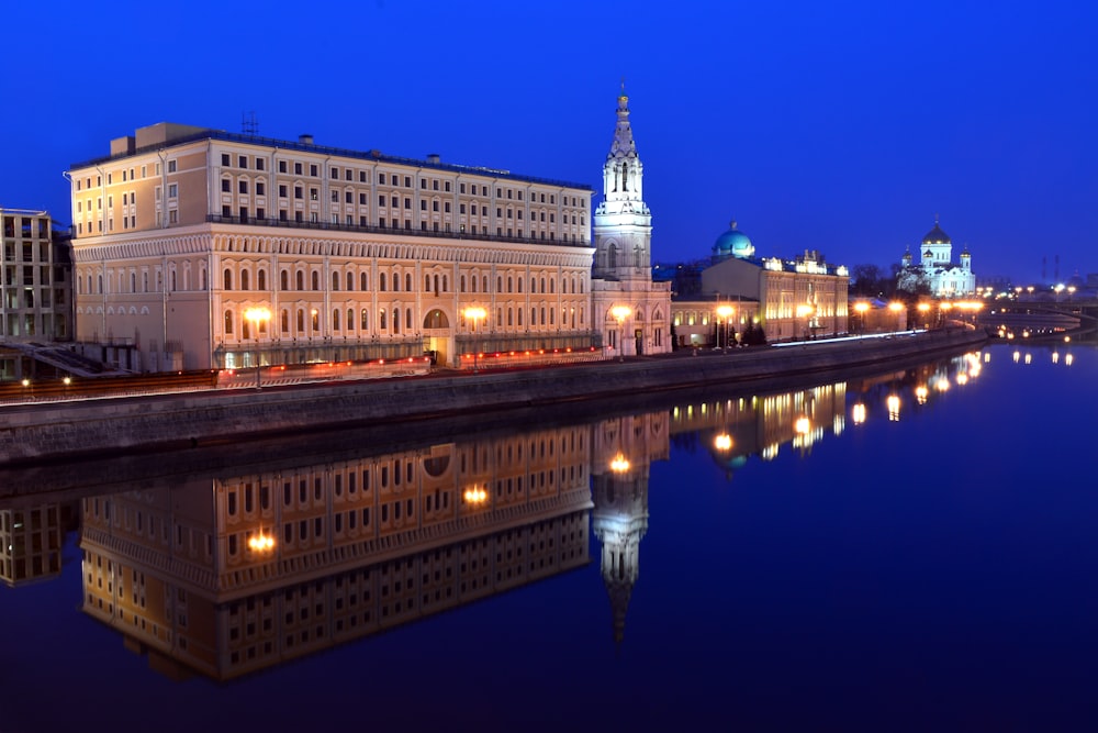 white concrete building near body of water during night time