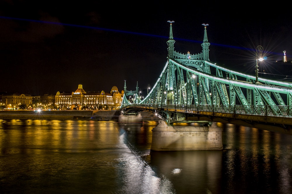 green bridge over river during night time