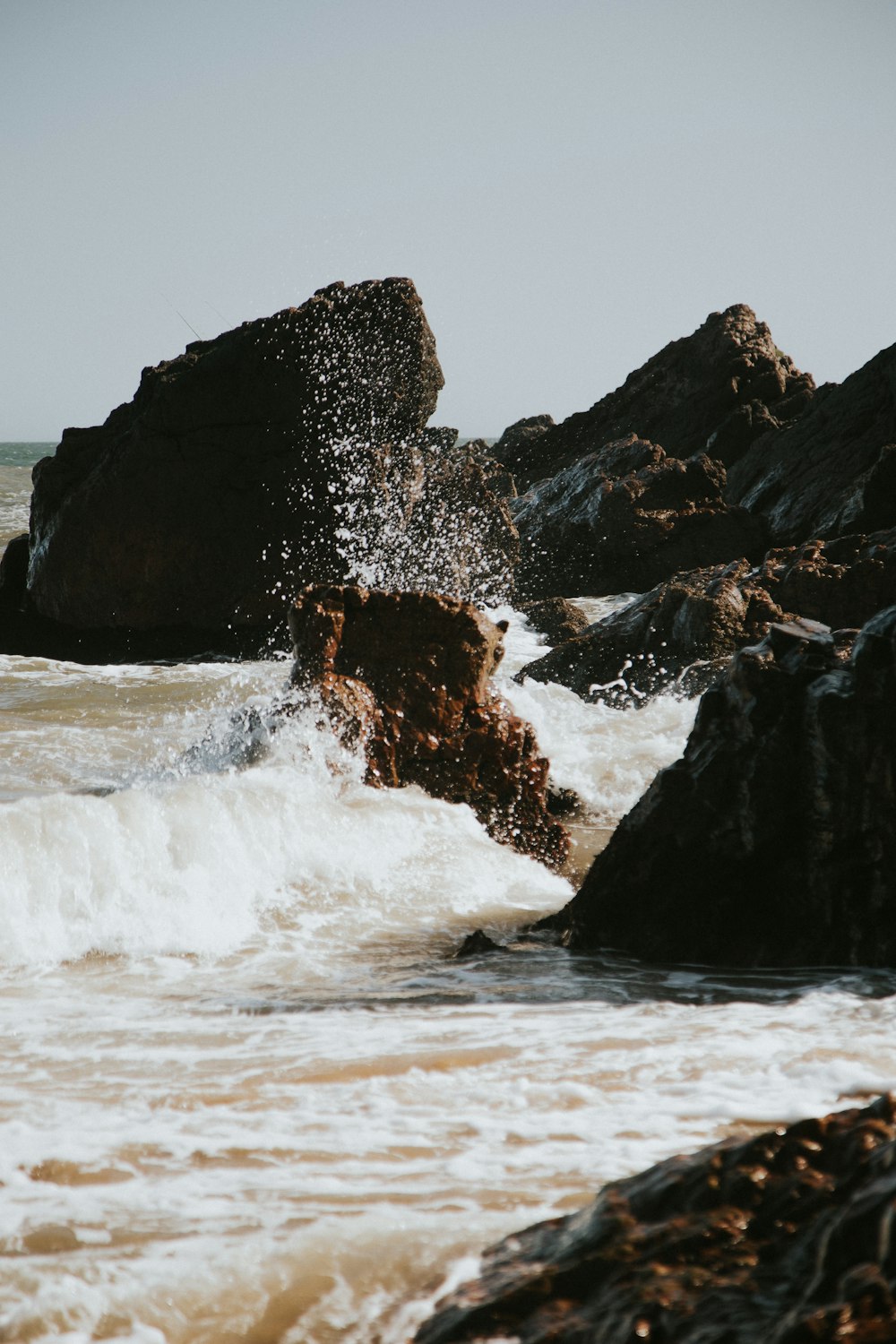 brown rock formation on sea water during daytime