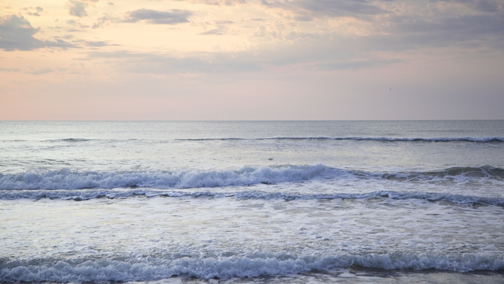 ocean waves under cloudy sky during daytime