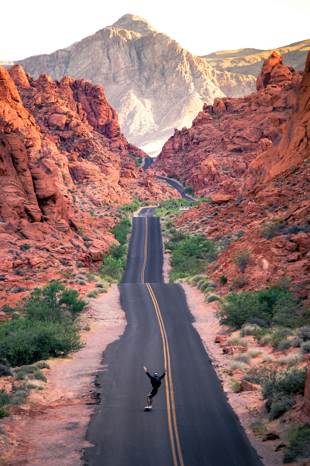 gray asphalt road between brown rocky mountains during daytime