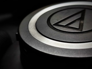 Close-up of a sleek, black 3D printed corporate logo with sharp edges.