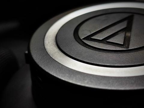 Close-up of a sleek, black 3D printed corporate logo with sharp edges.