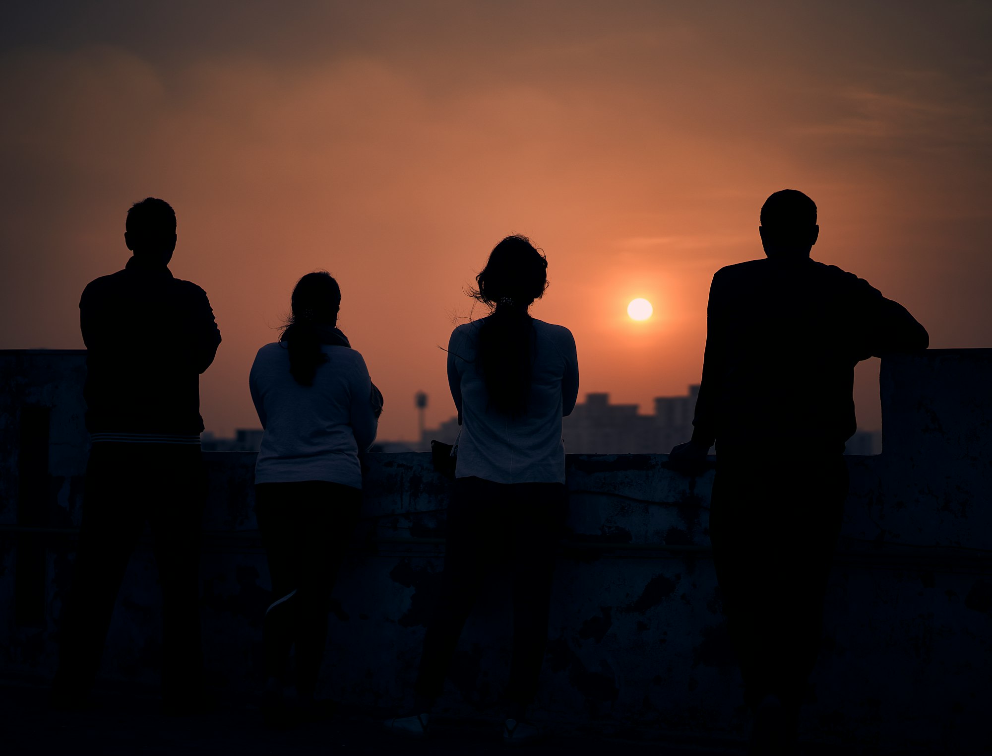 People standing on roof and enjoying sunset