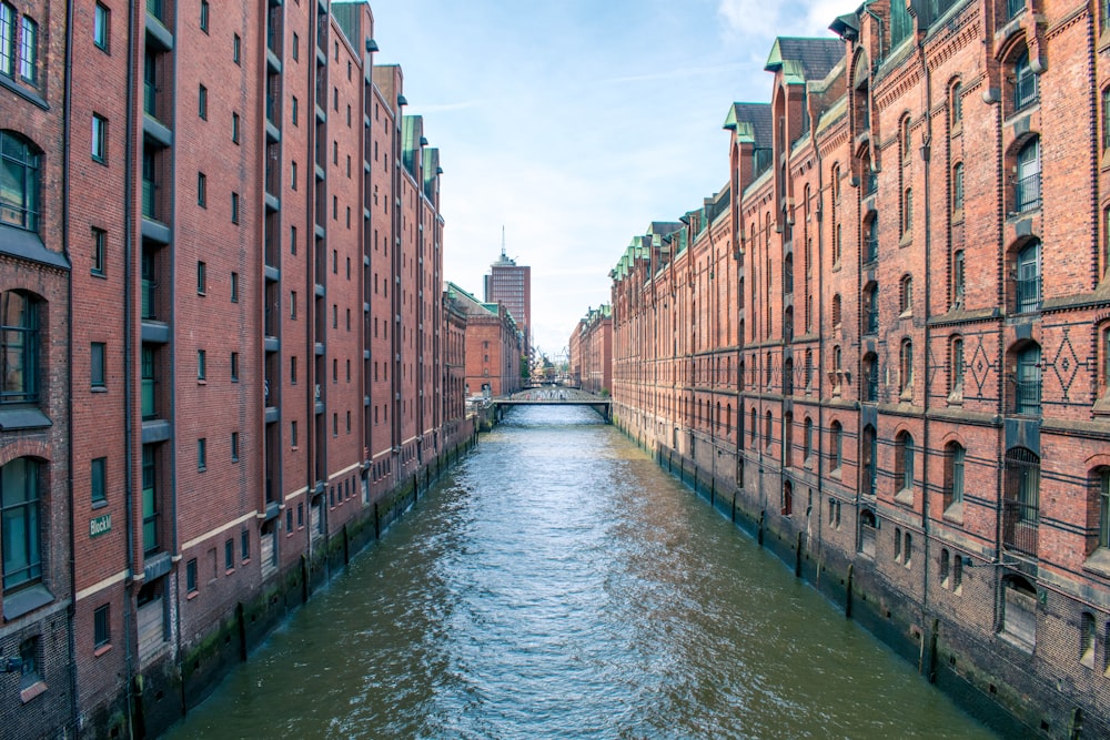 river between brown concrete buildings under blue sky during daytime