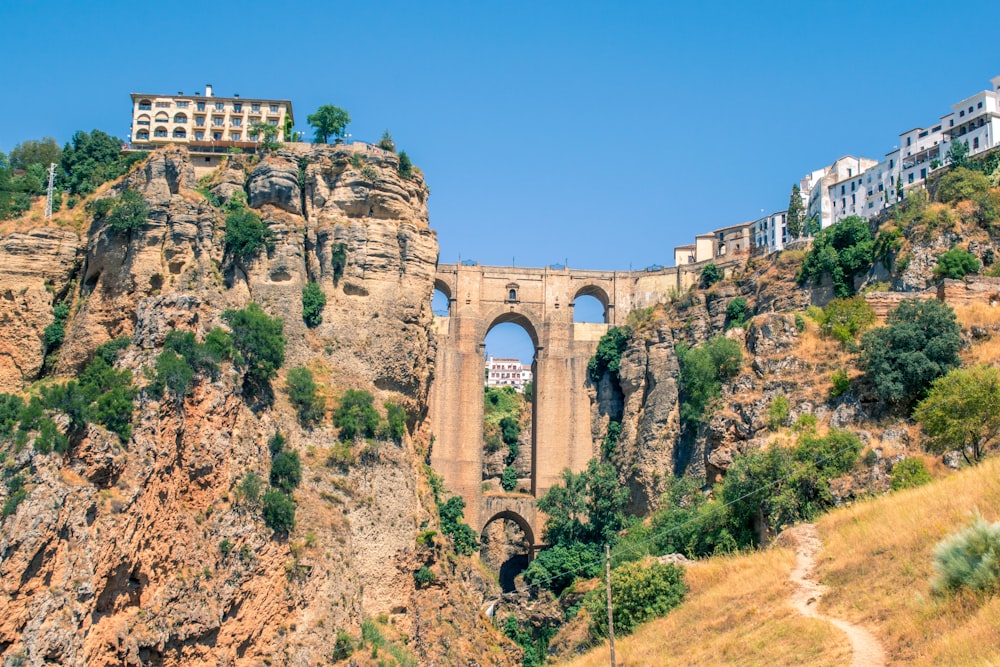 Bâtiment en béton brun près d’arbres verts sous un ciel bleu pendant la journée