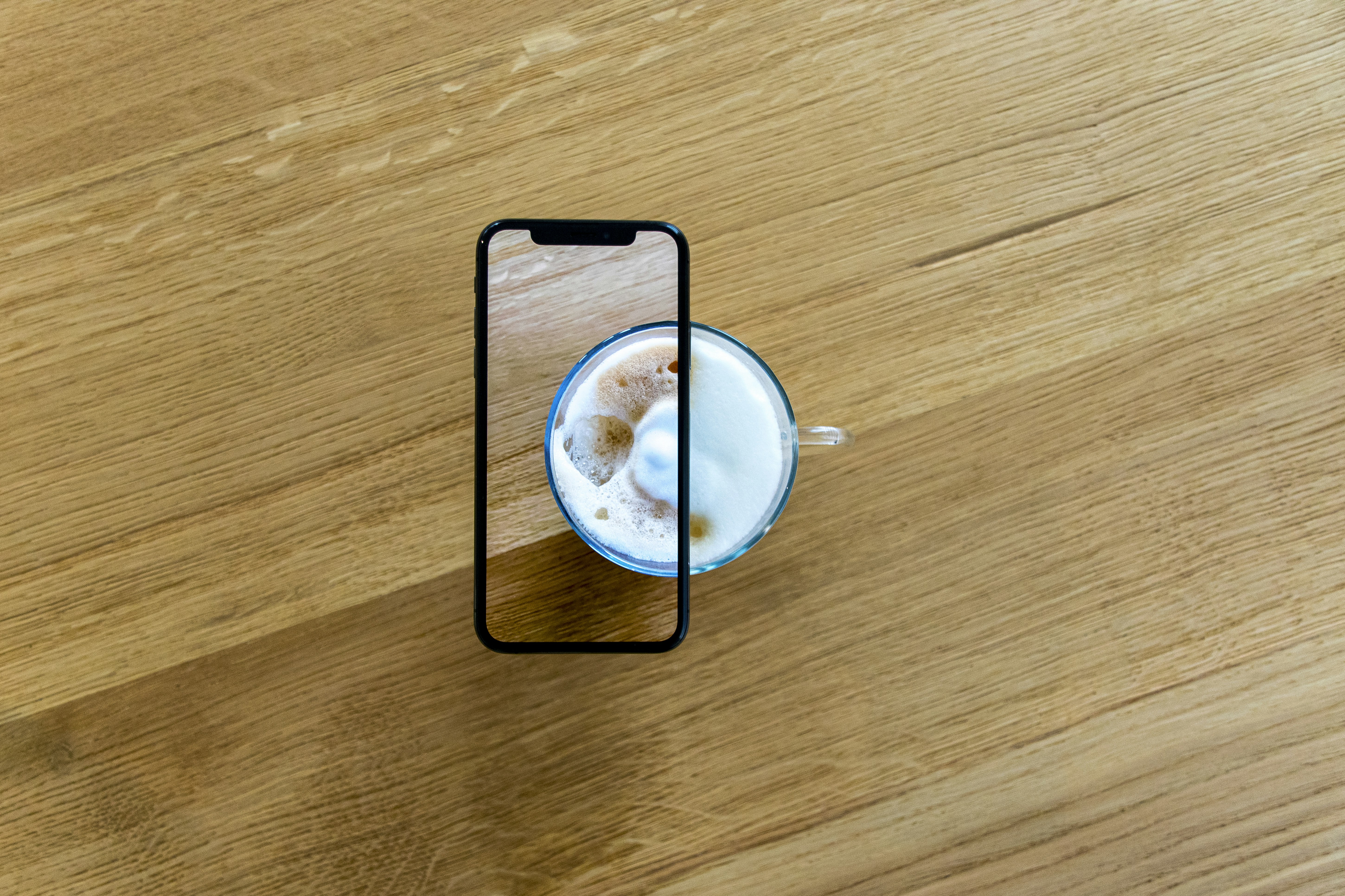 white and blue ceramic mug on brown wooden table