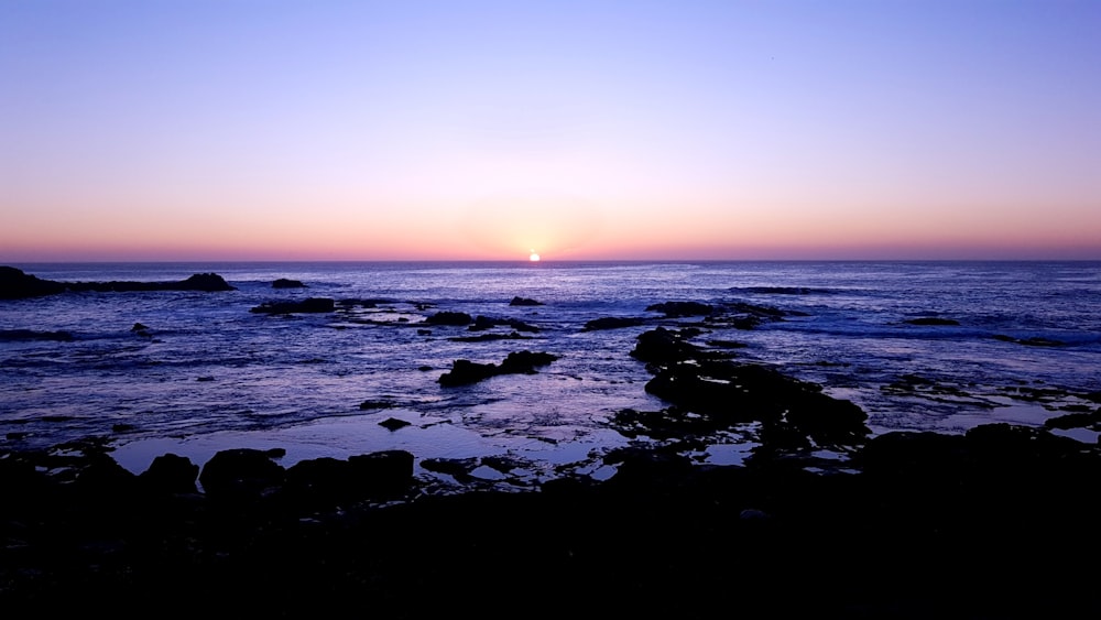 body of water during sunset