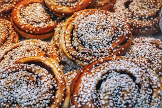 Close-up of a golden, swirled cinnamon roll with glistening sugar crystals and soft, flaky layers.