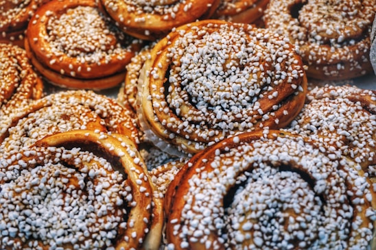 Close-up of a golden, swirled cinnamon roll with glistening sugar crystals and soft, flaky layers.