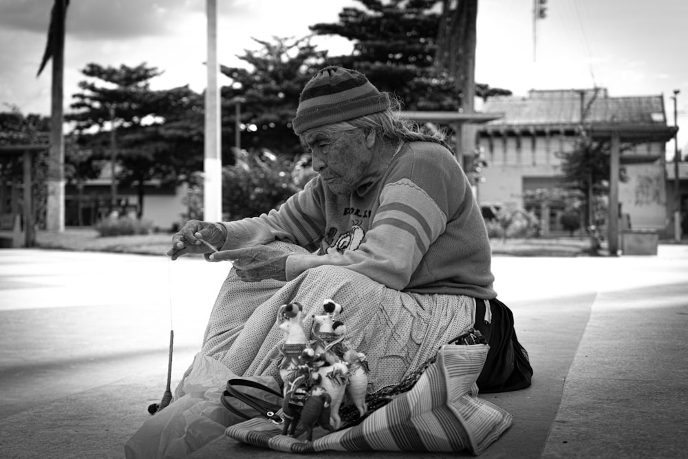 man in hoodie and pants sitting on floor with dog in grayscale photography