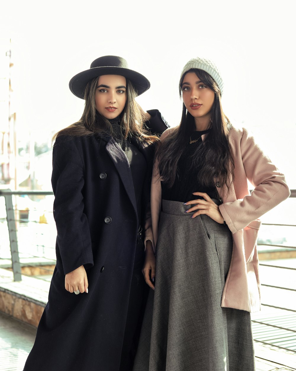 2 women in black coat standing on bridge during daytime