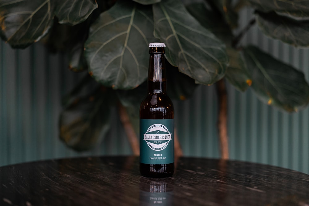 green leaf beside brown glass bottle