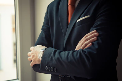 man in black suit jacket wearing silver watch