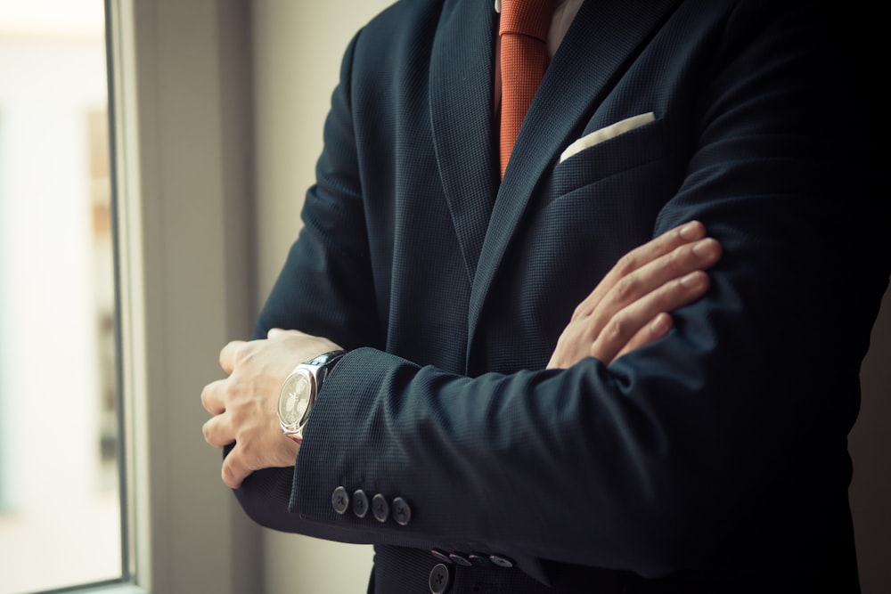 Mann in schwarzer Anzugjacke mit silberner Uhr
